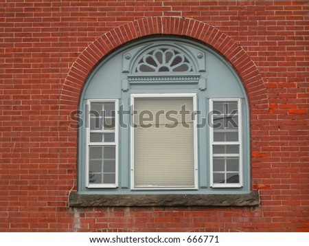THIRD STORY DECORATIVE WINDOW OF OLD RED BRICK HOME