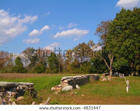 Old cemetery in rural Pennsylvania.  At the back of the cemetery is an old dry laid stone wall which has fallen apart in several areas.