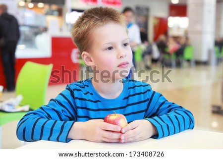 little boy with the apple in the cafe