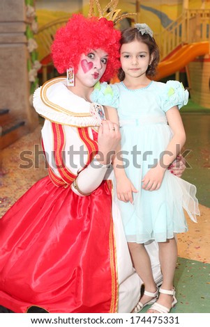 little girl posing with the young actress playing Red Queen closeup