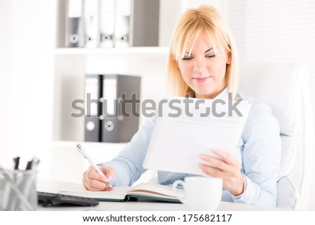 Businesswoman sitting at the table and working in the office.