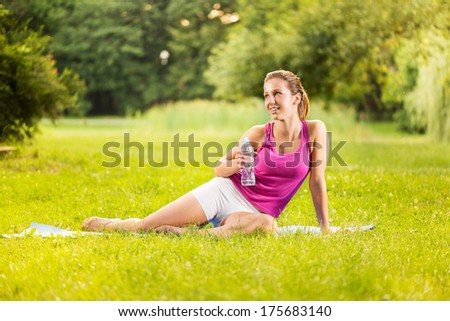 Beautiful young woman resting after exercising in the park.