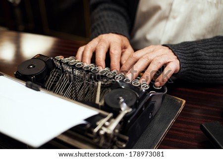 Senior man hands typing on Obsolete Typewriter.