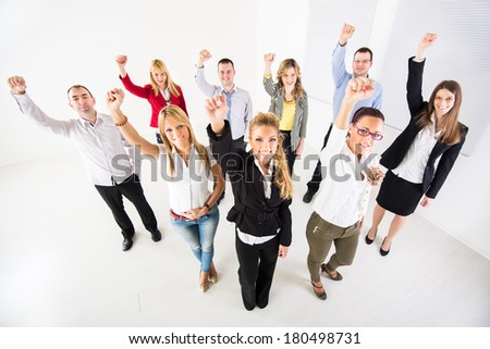 Group of a happy Business People standing together with raised arms in a fist.