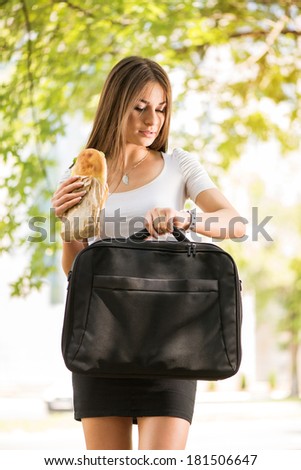 Overworked Businesswoman walking on the street looking on watch, eating Sandwich and late for work.