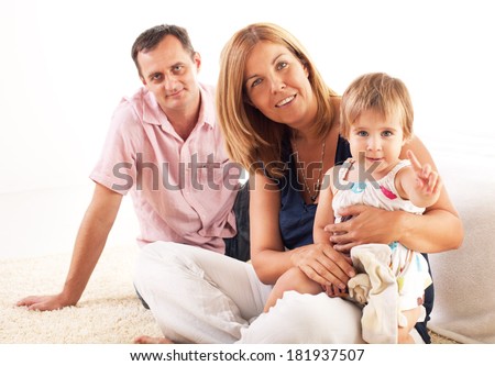 Beautiful happy family sitting on the floor and hugging each other