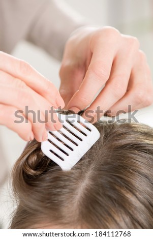Hairdresser putting hair Clips on a woman hair. Close-up.