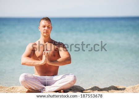 Young man meditating on the beach.