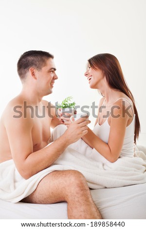 Romantic young couple drinking coffee for good morning in the bed.