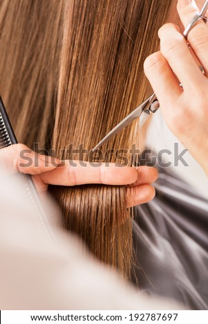 Hairdresser cut hair of a woman. Close-up.