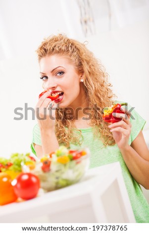 Beautiful young woman eating pepper in the living room