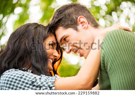 Close-up portrait of a young heterosexual couple in love to watch each other lovingly leaning their heads on each other.