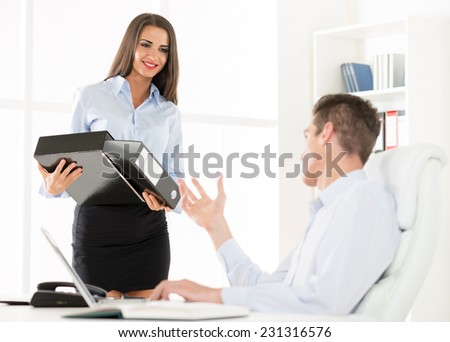 Young beautiful secretary and businessman working in the office.