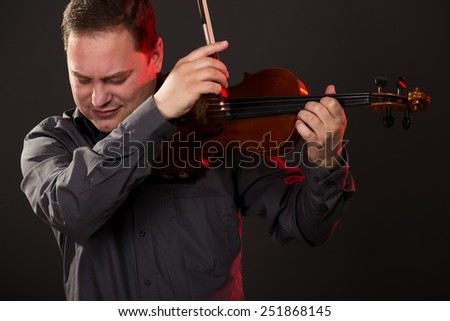 Close-up portrait of a young man playing the violin.