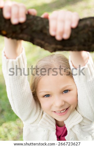 Beautiful funny little girl in the park at spring. Looking at camera.