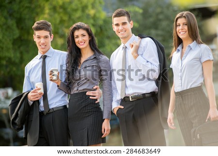 Successful young business team during a coffee break, walking on a park and enjoying a sunny day.