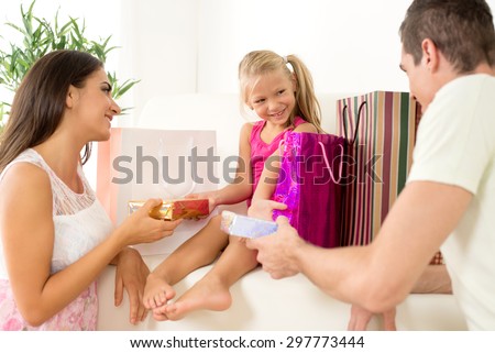 Beautiful young parents giving gift their cute little girl
