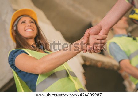 Close-up of a shaking hands of a construction workers in building damaged in the disaster. Selective focus.