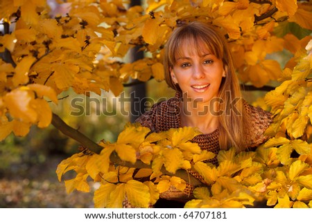 Young beautiful woman united with nature in autumn