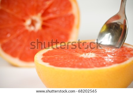 Halved red grapefruit with spoon