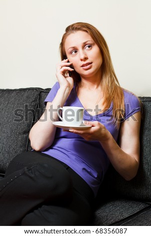 Woman with Coffee Talks on Cell Phone