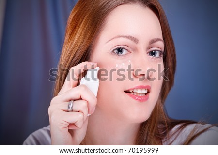 Woman is putting Anti-Wrinkle cream on face