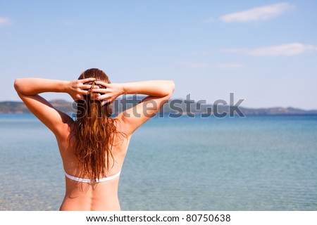 young woman on the beach with hands in hair