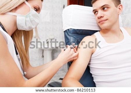 Young man getting flu shot needle vaccination in arm