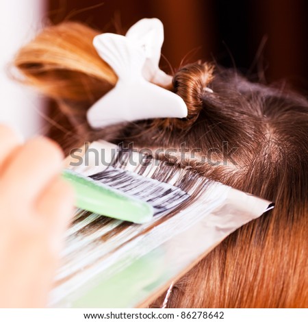 Coloring hair with hair coloring brush / Close-up