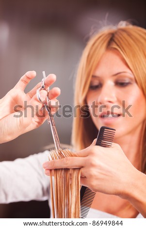 Hairdresser cut hair of a blonde woman