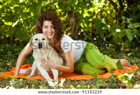 Happy young woman and dog in a forest