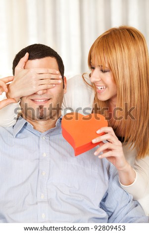 Woman surprising man with gift