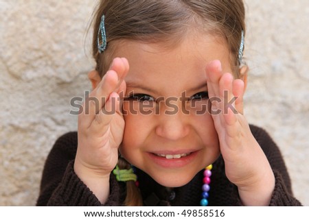 A young girl playing a game of peek a boo