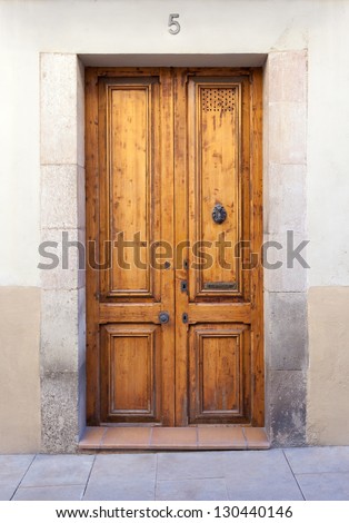 A classic double wooden door with a knocker and a mail slot (labeled \