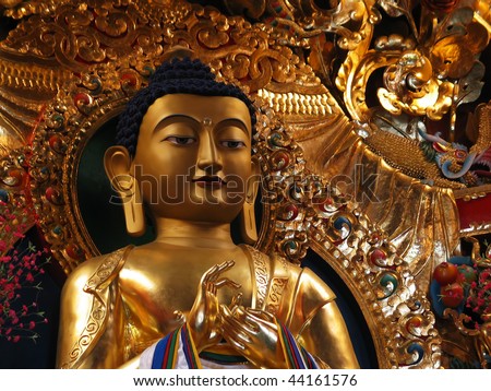 gilded metal statue of preaching Buddha in a Tibetan Buddhist monastery in Sarnath, India