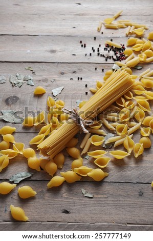 Cooking concept. Uncooked italian pasta: vermicelli, spaghetti with twine on wooden background