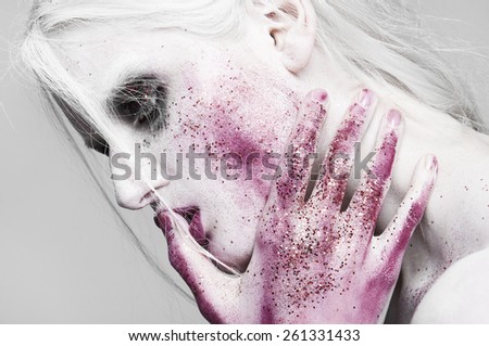 White hair. Woman with face art and body art. Painted girl portrait on white background in studio.