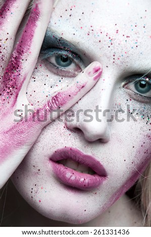 White hair. Woman with face art and body art. Painted girl portrait on white background in studio.