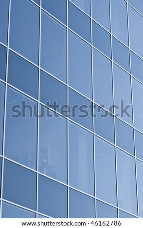 A modern office building made of glass, blue professional hue