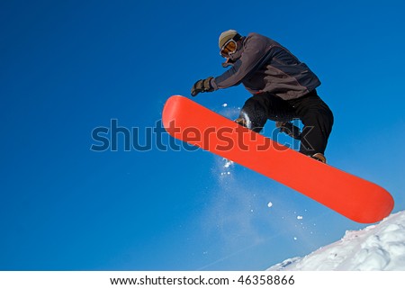 Extreme sports: snowboarder flying in air, snow crystals flying everywhere