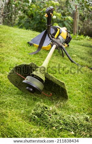 Petrol trimmer on the sloped lawn in the garden