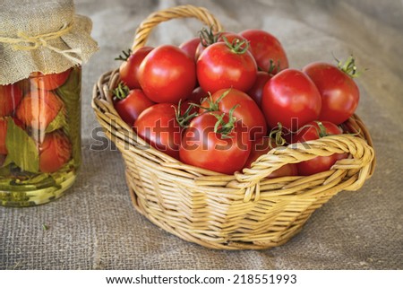 Still life of a basket of tomatoes, canned goods, on canvas