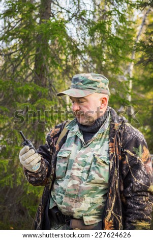 Huntsman in forest includes a radio to talk