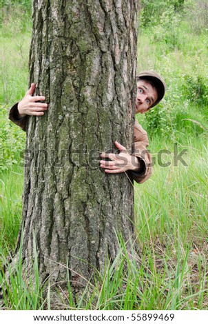 Man hugging tree with fear on face