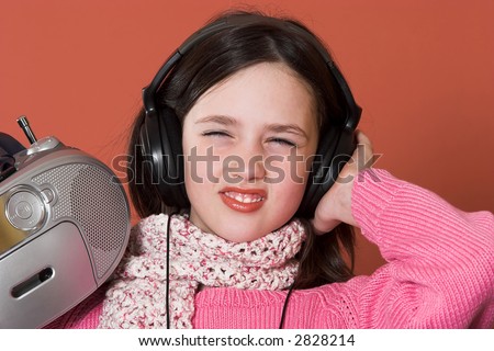 pretty girl listening music with headphones and holding portable CD radio