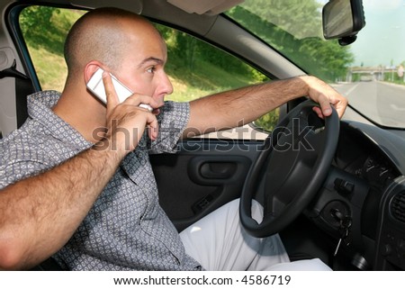 Businessman hold mobil phone during driving