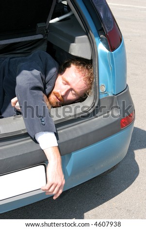 Dead man in car boot - stock photo