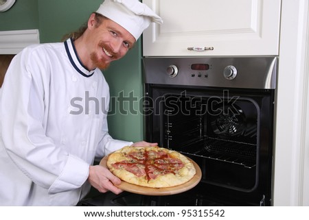 young chef with italian pizza in kitchen
