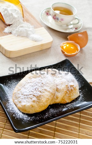 Batter fried in deep oil with sugar powder and a cup of tea - Bulgarian breakfast