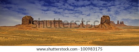 A panoramic photograph of the red rock buttes as seen from Artist\'s Point in the Monument Valley region of the Colorado Plateau that spans the northern border of Arizona and southern border of Utah.